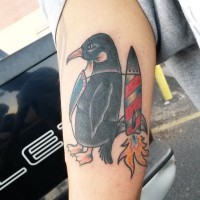 Tatuaje en el brazo,
pingüino atado a cohete , estilo old school