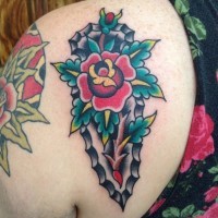 Tatuaje en el hombro, arma antigua decorada con rosa y hojas, old school