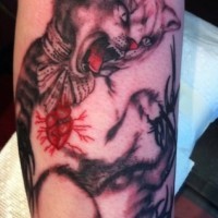 Tatuaje en el brazo, gato furioso con corazón humano