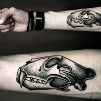 Old school dot style forearm tattoo of ancient animal skull