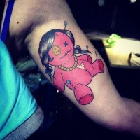 Oldschool mehrfarbiges Arm Tattoo mit cartoonischer Voodoo Puppe