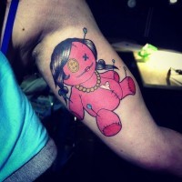 Old school multicolored arm tattoo of cartoon voodoo doll