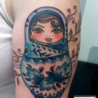 Old school simple designed and colored matryoshka tattoo on shoulder stylized with leaves