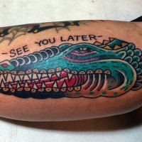 Old school style colored alligator head with lettering tattoo on arm