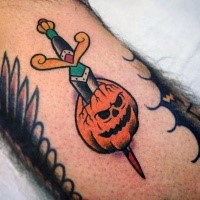Old school style colored arm tattoo of pumpkin with dagger