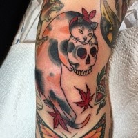 Old school style colored arm tattoo of cat with human skull