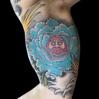 Old school style colored biceps tattoo of big flower stylized with daruma doll