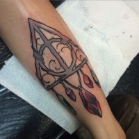Old school style colored big triangle tattoo on forearm with colored stones