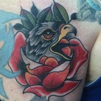 Tatuaje en el hombro, rostro de águila entre flores, estilo old school multicolor