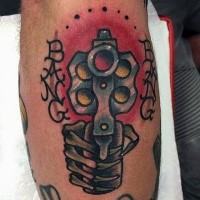 Old school style colored leg tattoo of skeleton hand with revolver