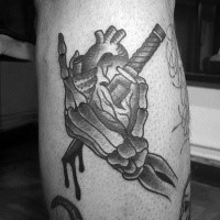 Old school style colored leg tattoo of  monster hand with dagger and human heart
