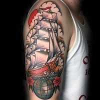 Old school style colored shoulder tattoo of sailing ship with globe