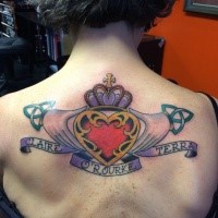 Old school style colored upper back tattoo of hands holding heart with cross and lettering