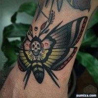 Old school style colored wrist tattoo of butterfly stylized with human skull