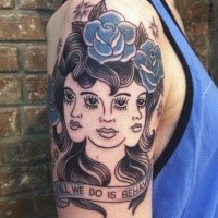 Old school style creepy looking woman with blue flowers tattoo on shoulder stylized with lettering