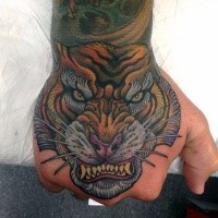 Old school style naturally colored furious tiger's head tattoo on hand