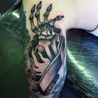 Old school style painted black ink coffin with skeleton hand tattoo on arm