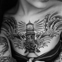 Old school style painted lighthouse tattoo on chest with flower and big waves