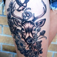 Tatuaje en el muslo,  ciervo joven bonito entre flores y ave pequeña