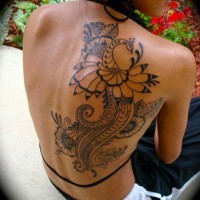 Old style black and white flower shaped bird tattoo on shoulder