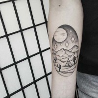 Old style black ink oval shaped tattoo on forearm stylized with night desert and Indian house