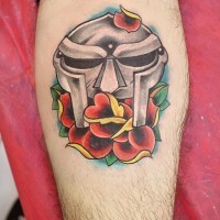 Old style colored antic warriors helmet tattoo on leg stylized with flower
