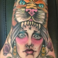 Old style designed and colored small hand tattoo of tribal woman with lion skin helmet