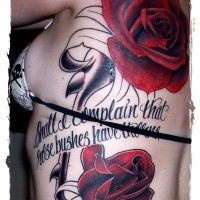 Old style half colored big roses with lettering tattoo on back