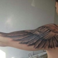Ein schwarzer Flügel Tattoo am Arm