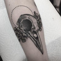Tatuagem de antebraço de tinta preta original de caveira de pássaros e flores