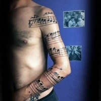 Original black ink sleeve tattoo of song notes with lettering