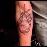Original colored forearm tattoo of human heart with labyrinth