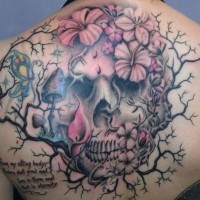 Tatuaje en la espalda,
cráneo en el árblos entre flores