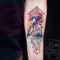 Tatuaje en el antebrazo, libro con ballena y montañas