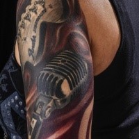 Original painted and colored shoulder tattoo of guitar with microphone