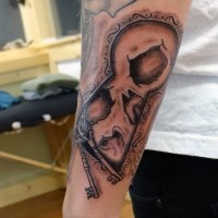 Original painted antic lock with keys and skull tattoo on arm