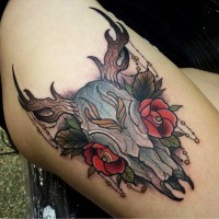 Tatuaje en el muslo,  cráneo animal multicolor con flores rojas