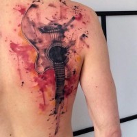 Tatuaje en la espalda, guitarra acustica con manchas de pintura