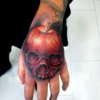 Original painted colored skull shaped apple tattoo on hand