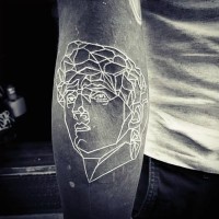 Tatuaje en el brazo, rostro de hombre antiguo en el fondo negro