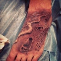 Picture style colored hand tattoo of foot prints with lettering