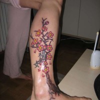 Tatuaje en la pierna, árbol con flores pintoresco
