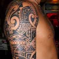 Polynesian style black ink shoulder tattoo of various ornaments