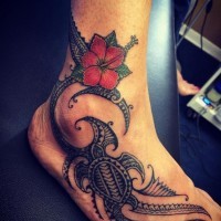 Polynesian tribal style swimming turtle tattoo and colored Hibiscus flower on foot and ankle