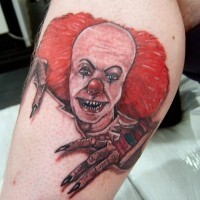 ritratto di terribile pagliaccio con capelli rossi da sotto pelle tatuaggio su gamba