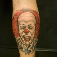 Portrait of a terrible red haired clown tattoo on leg
