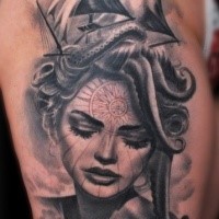 Portrait style black and white thigh tattoo of woman portrait and sailing ship