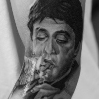 Portrait style colored arm tattoo of smoking mafioso