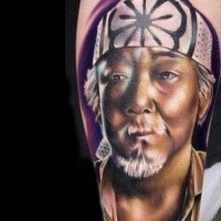 Portrait style colored arm tattoo of Asian man face