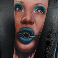 Portrait style colored forearm tattoo of woman face with chain